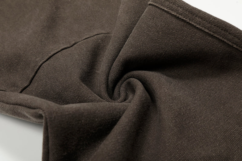 Close-up of brown pants fabric folds and stitched seam detail