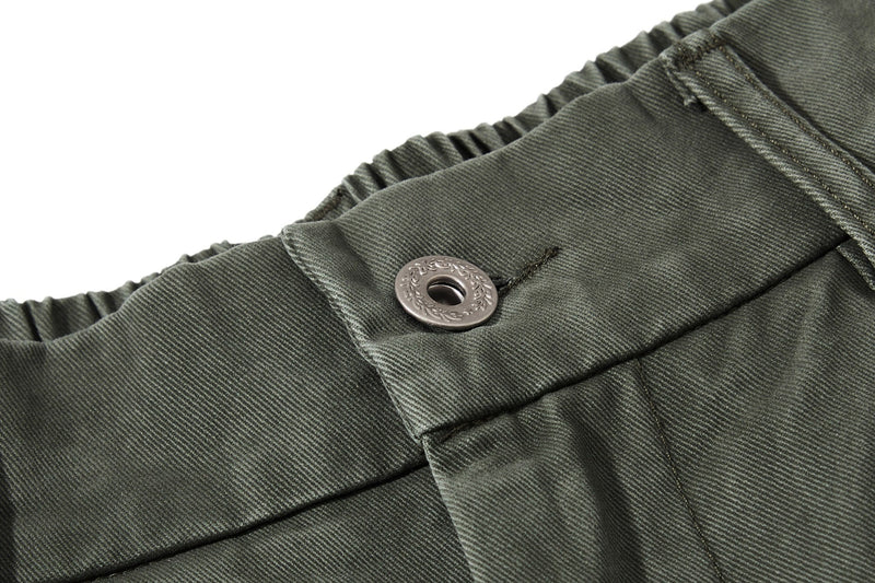 Close-up of olive green waistband with button and elastic back
