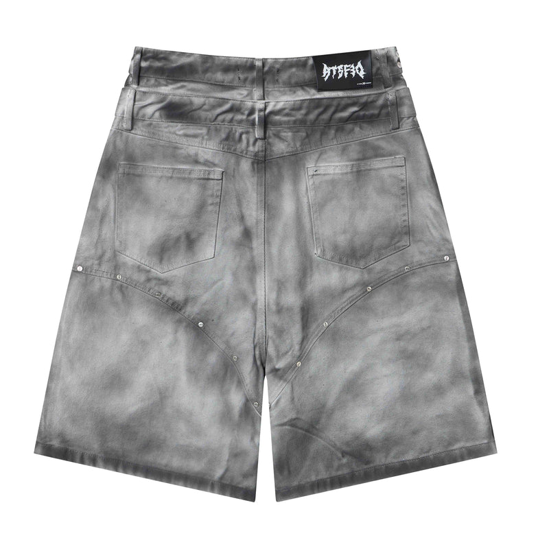 Gray denim jorts front view with studded curved seam details and back pockets