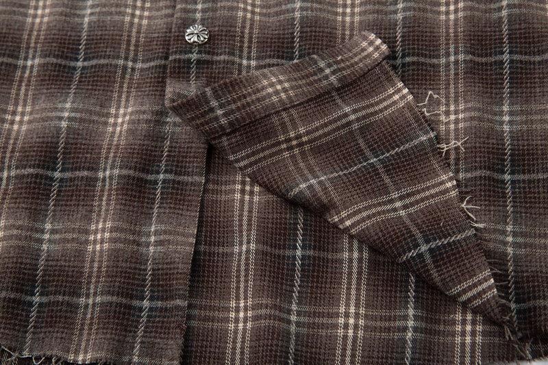 Brown plaid sleeve cuff with raw-edge distressing over cream long sleeve