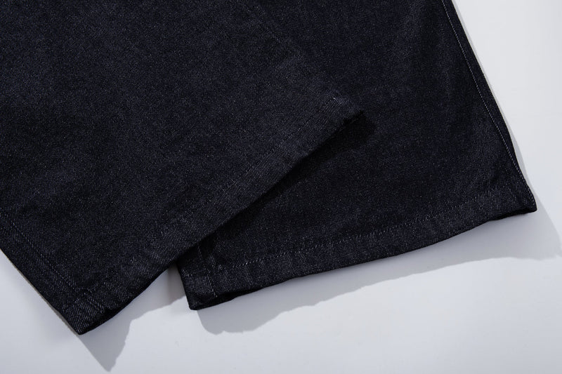 Close-up of the wide hem and dark indigo denim texture on the pant leg