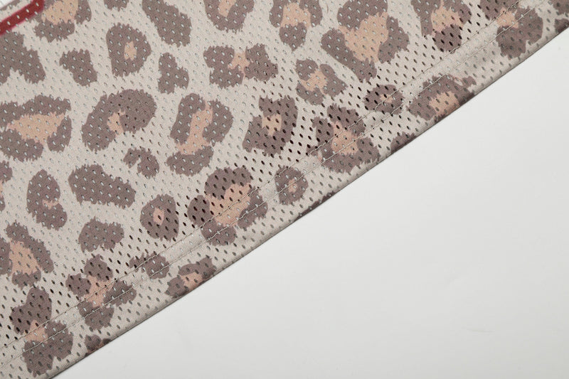 Close-up of leopard print mesh jersey hem with stitched edge and breathable sportswear fabric detail