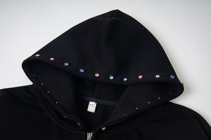 Close-up of black hoodie hood with multicolor rhinestone studs along the edge