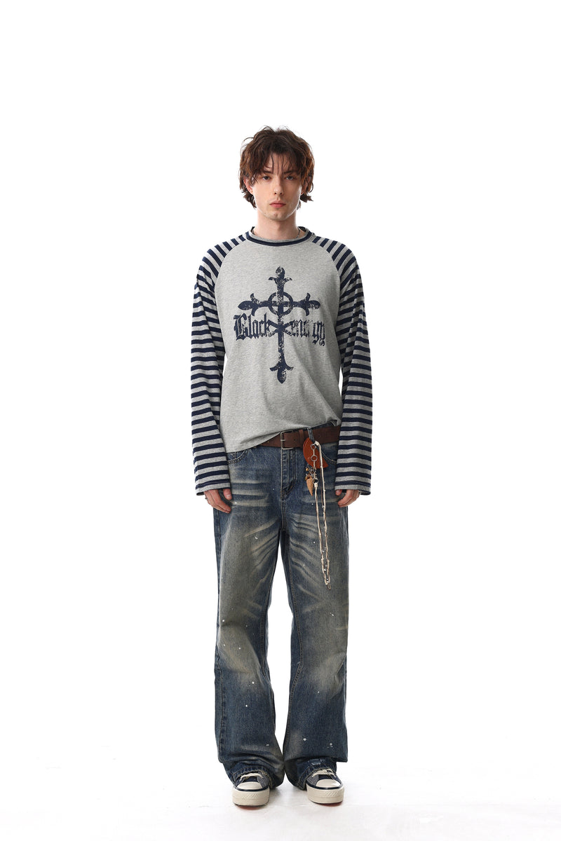 Front view of gray raglan tee with navy striped sleeves and gothic cross print on model