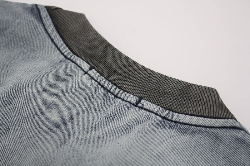 Close-up of a vintage washed distressed T-shirt collar with ribbed trim and faded denim-blue fabric detail