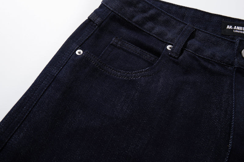 Close-up of dark wash jeans front pocket, belt loop, and waist stitching