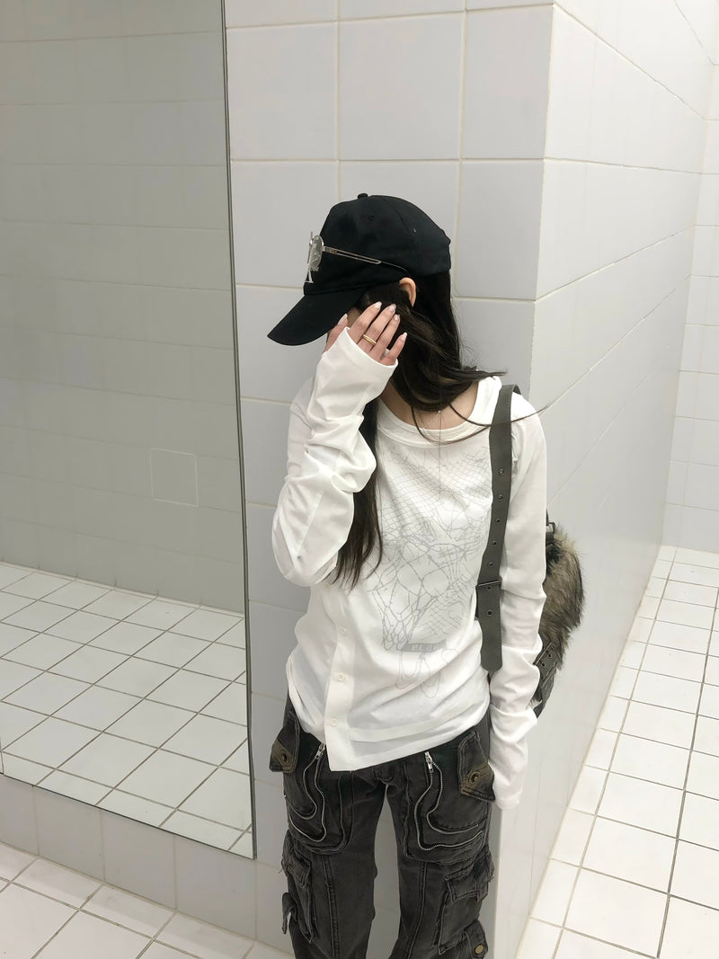 Model wearing white graphic long sleeve tee with abstract gray print and black cap
