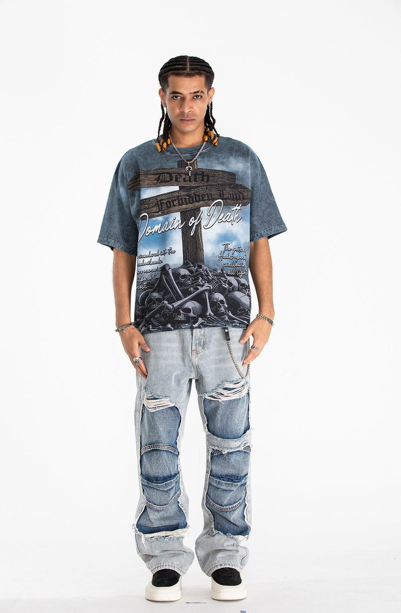 Model wearing a gothic graphic tee with skull pile print and Domain of Death text, styled with ripped baggy jeans