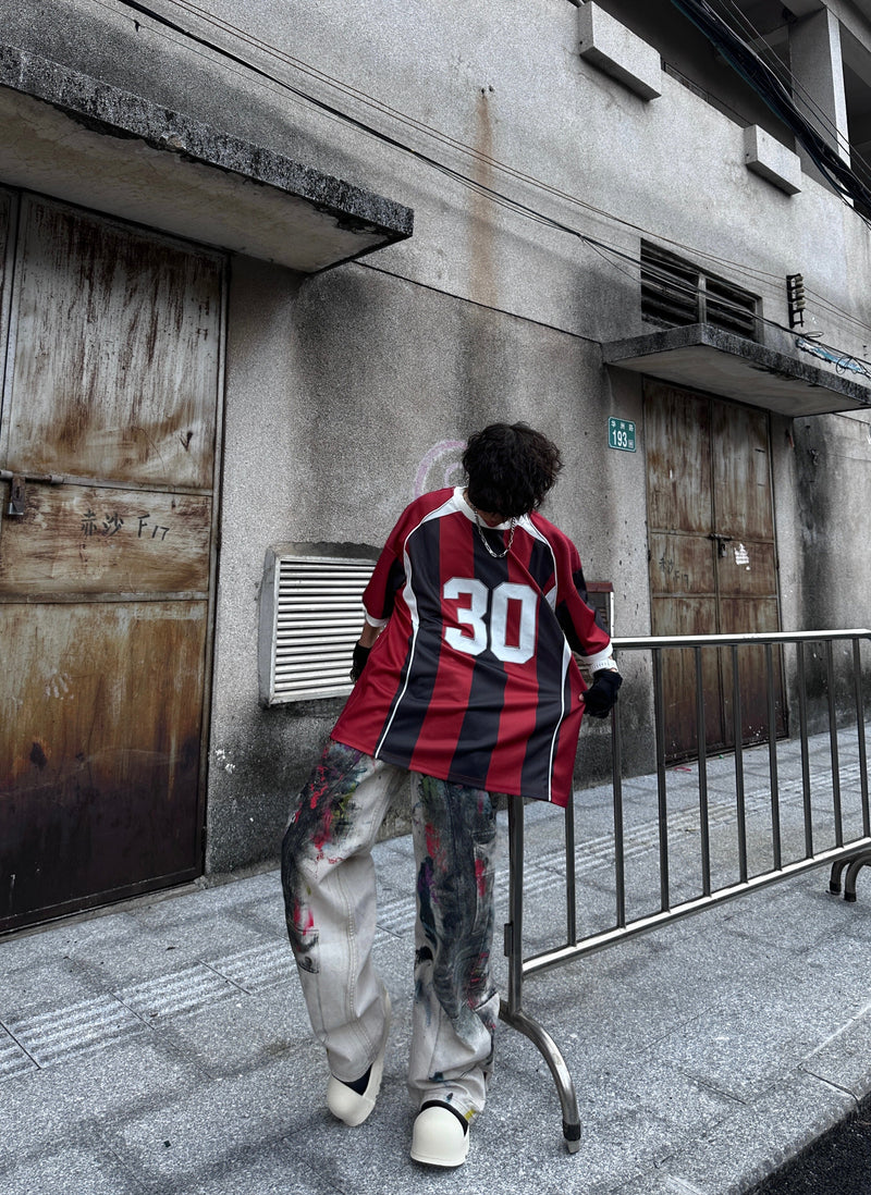 Oversized red and black vertical stripe soccer jersey tee with number 30, styled in an urban streetwear outfit
