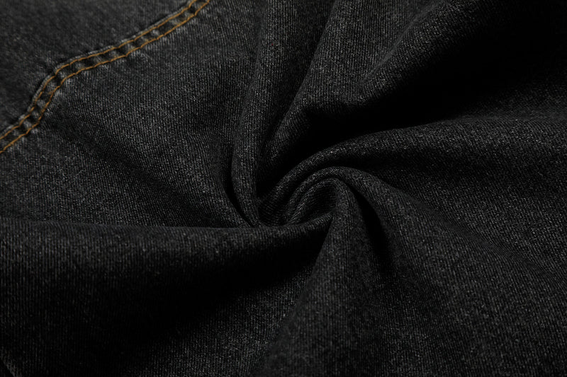 Close-up of black denim fabric texture with stitched seam