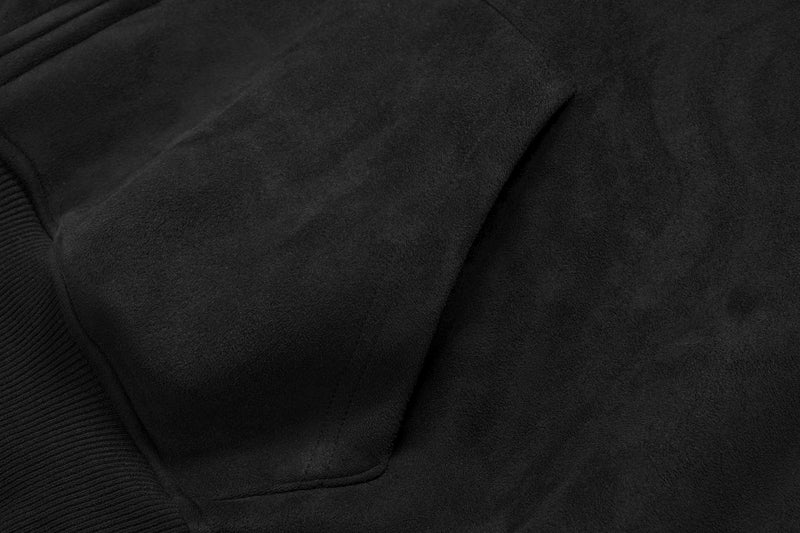 Close-up of black suede hoodie sleeve and shoulder seam with smooth textured fabric