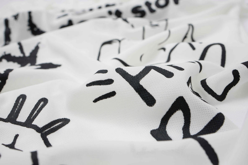 Close-up of white fabric with black distressed rock graphic print
