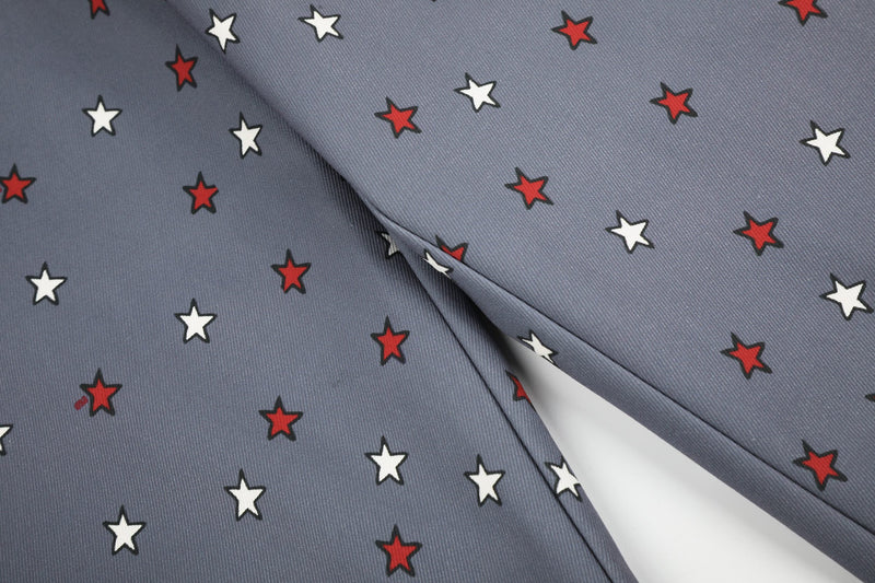 Close-up of gray denim fabric with scattered red and white star print