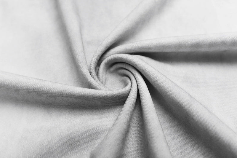 Close-up of soft white T-shirt fabric with smooth folded swirl texture and fine knit detail