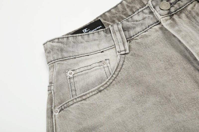 Close-up of front left pocket and waistband on faded gray jeans