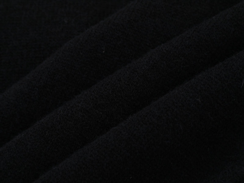 Close-up of black knit fabric texture with soft fuzzy finish