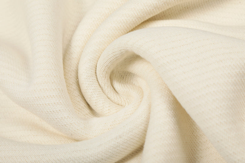 Close-up of cream sweatshirt fabric folded into a swirl