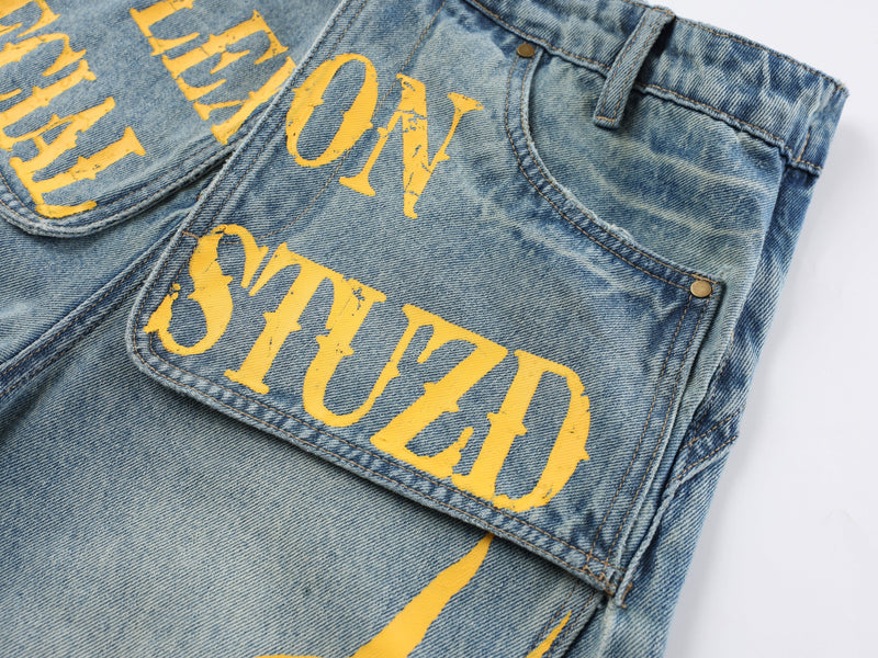 Close-up of the front and side pocket area with bold yellow lettering on denim