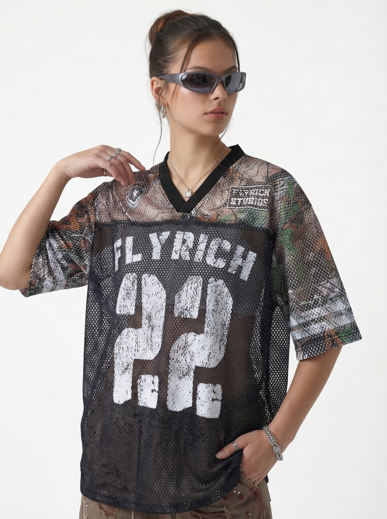 Model wearing a camo mesh jersey T-shirt with Fly Rich 22 graphic, black V-neck trim, and streetwear style
