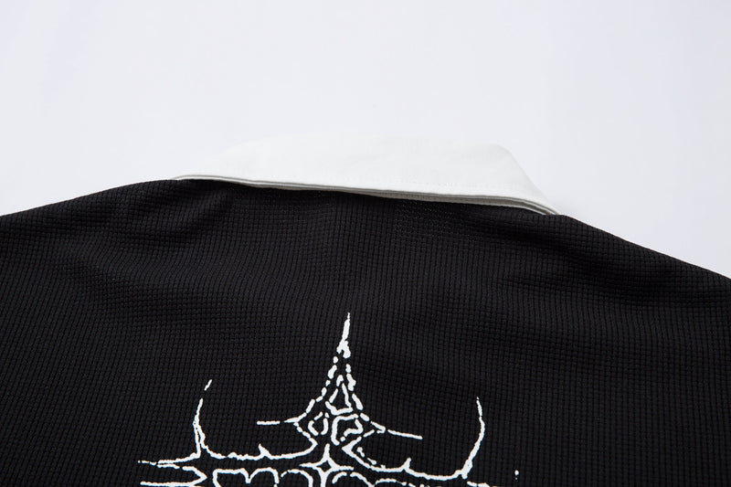 Black waffle-knit polo shirt with a white collar and gothic thorn cross graphic on the chest