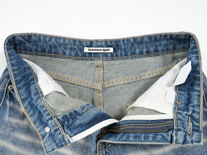 Interior waistband close-up showing brand label and zipper lining in denim shorts