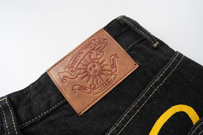 Close-up of tan leather-style back patch on black jeans waistband