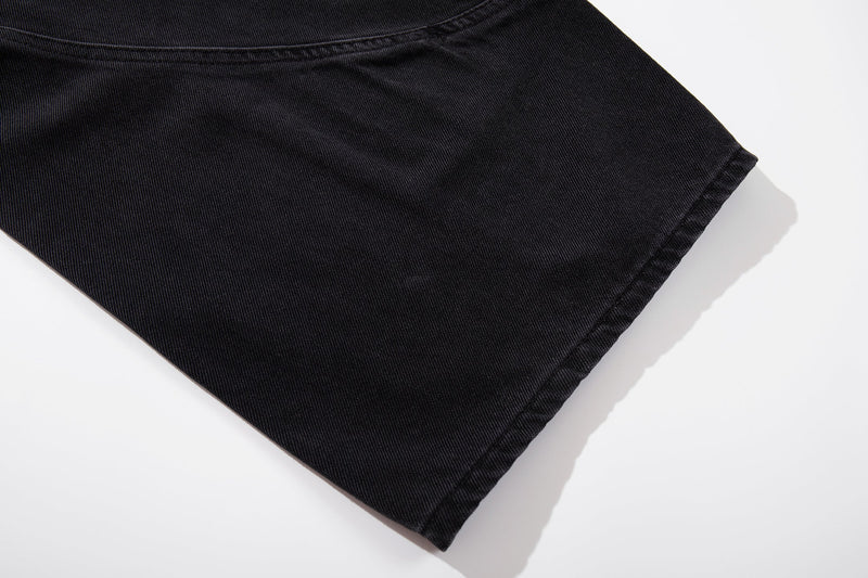 Close-up of dark denim leg opening and hem stitching