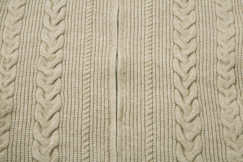 Close-up of beige cable knit sweater jacket front with zipper closed