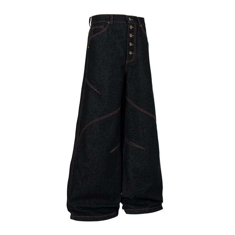 Angled front view of black wide leg denim pants with curved seam detailing and button fly