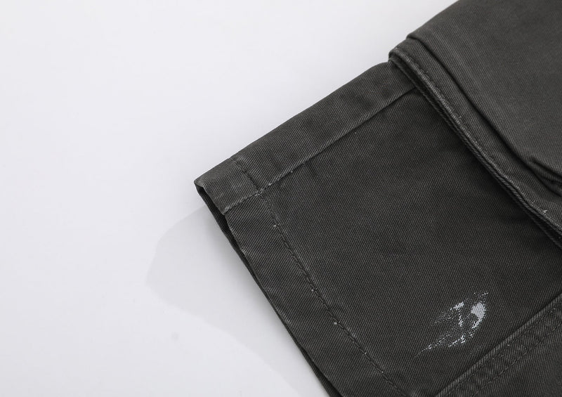 Black shorts hem close-up showing cuffed edge and distressed white scuff mark