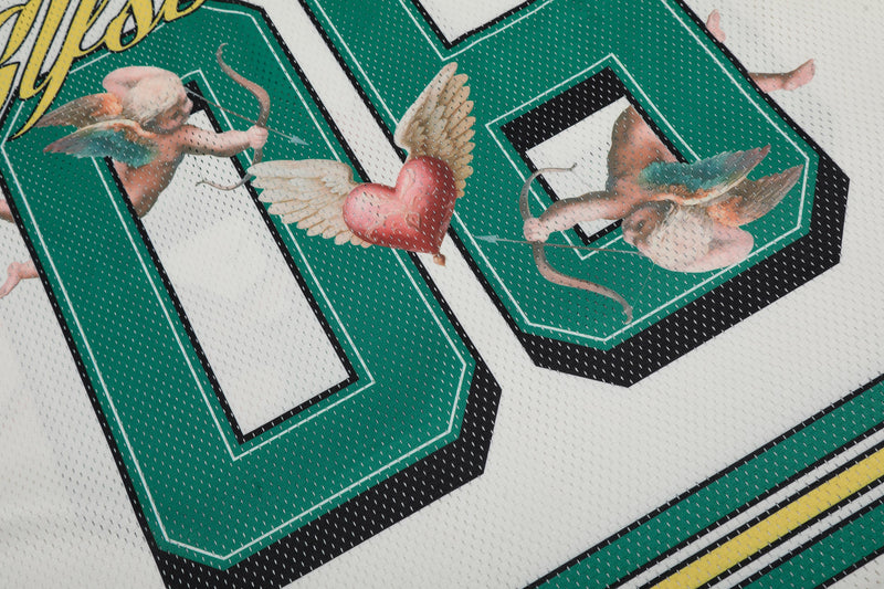 Close-up of a white mesh football jersey with green varsity lettering and angel graphics with a winged heart design