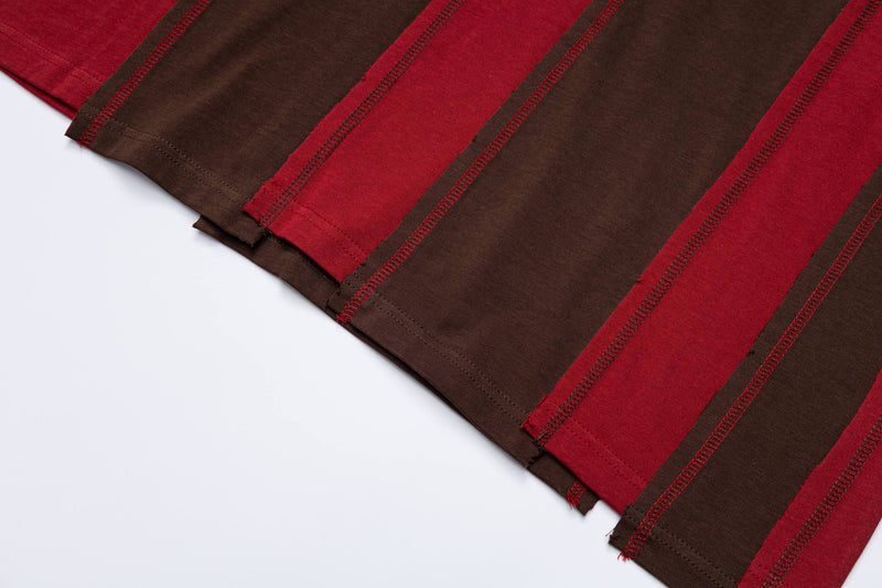 Close-up of oversized retro striped tee in red and brown with visible hem stitching on a white background