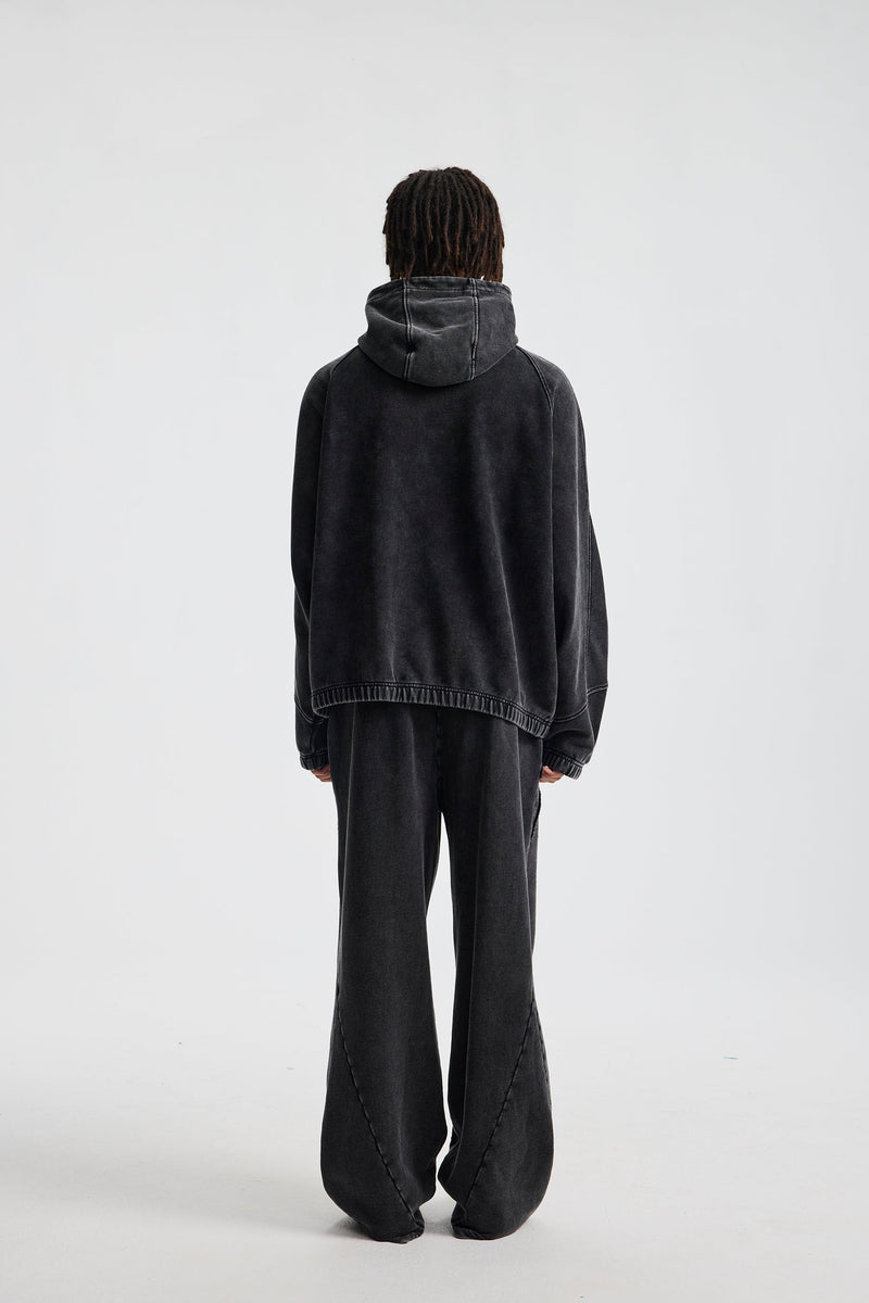 Back view of a black hoodie with hood up and soft washed cotton finish