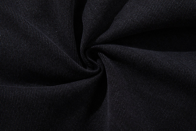 Close-up of black denim fabric texture with soft folded drape