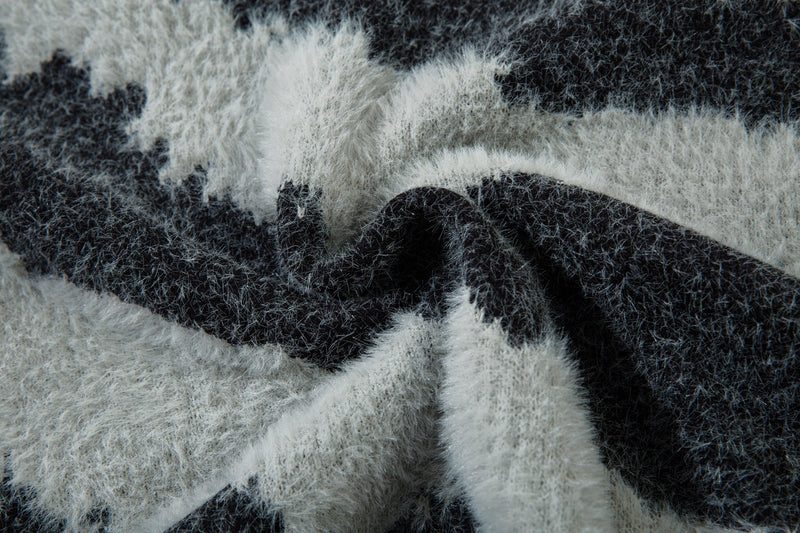 Close-up of black and white fluffy knit sweater fabric with zebra print folds