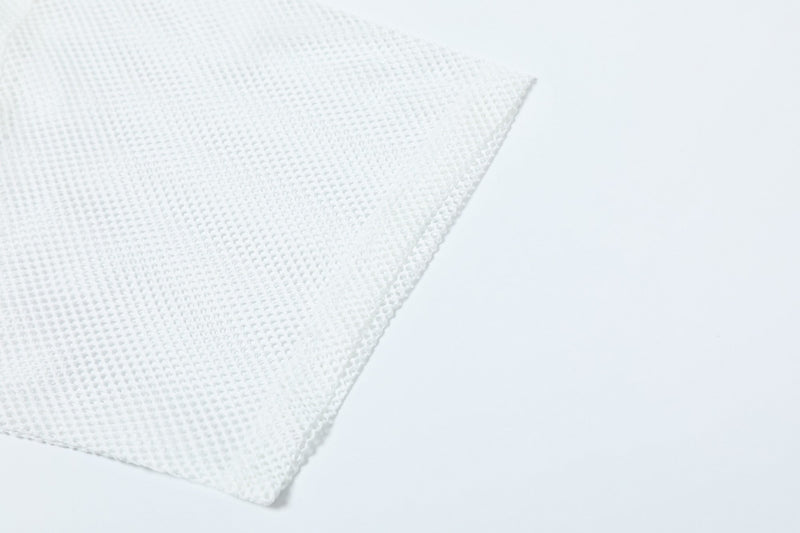 Close-up of white mesh jersey fabric with oversized athletic streetwear texture on a clean background