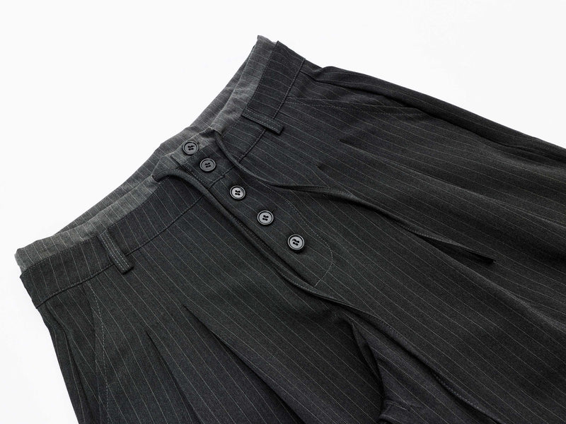 Angled front close-up of charcoal pinstripe shorts with button fly and waistband