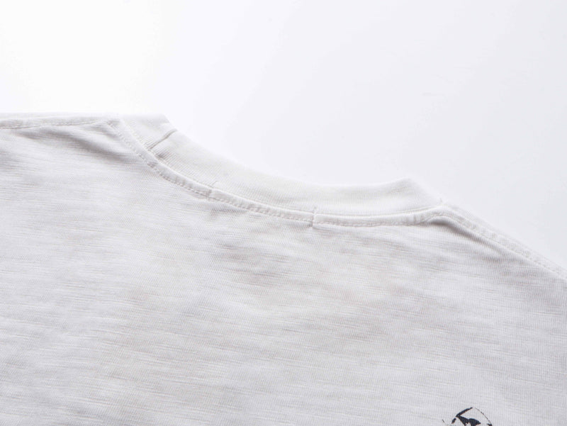Close-up of shoulder seam and upper collar on white long sleeve tee