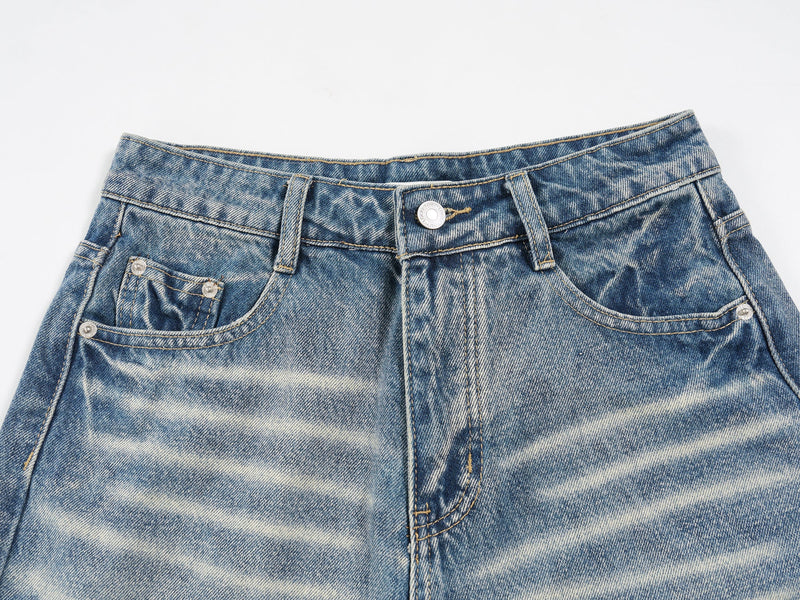Close-up of the front waistband and pockets on vintage wash denim shorts