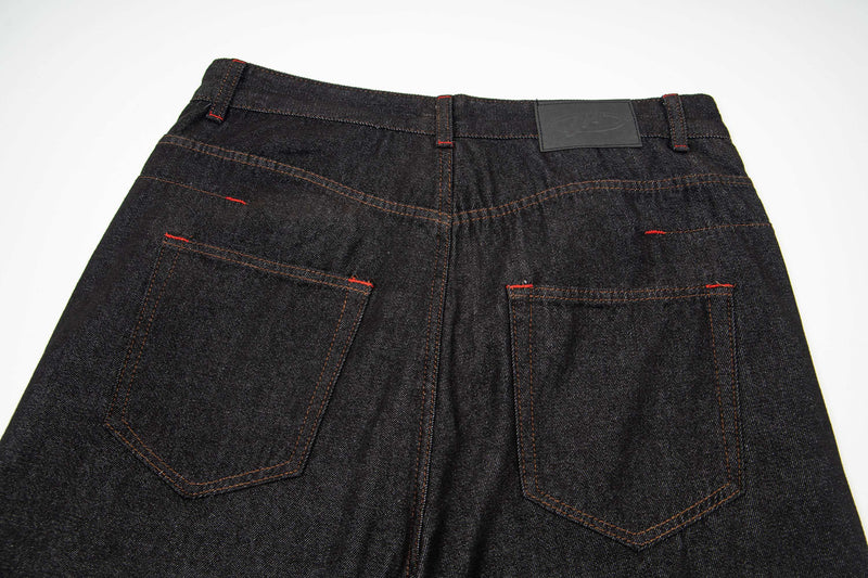 Back waist view of dark wash denim pants with patch label and rear pockets