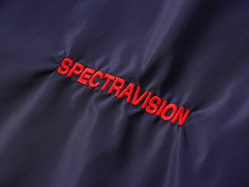 Close-up of Spectravision chest embroidery on navy nylon pullover