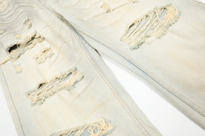 Cream wide-leg jeans with ripped knees and distressed front leg detail