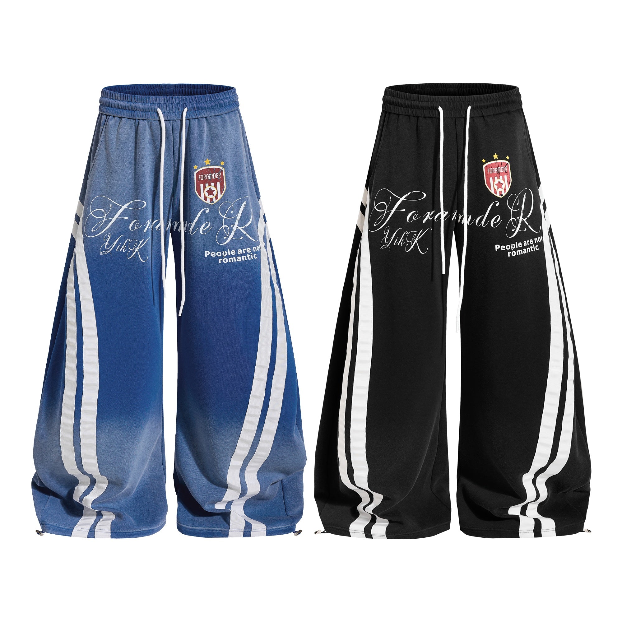 Gradient blue and black oversized balloon track pants with white racing stripes and script logo print, shown side by side