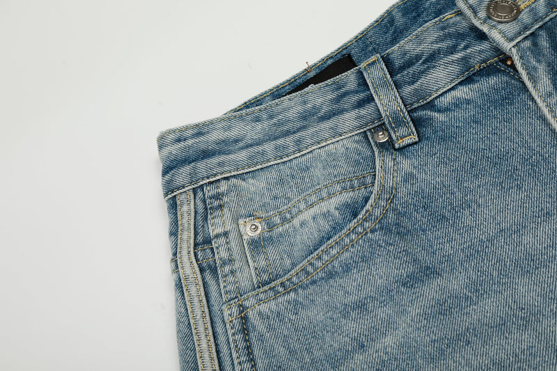 Close-up of front pocket and waistband on light wash barrel jeans with denim texture