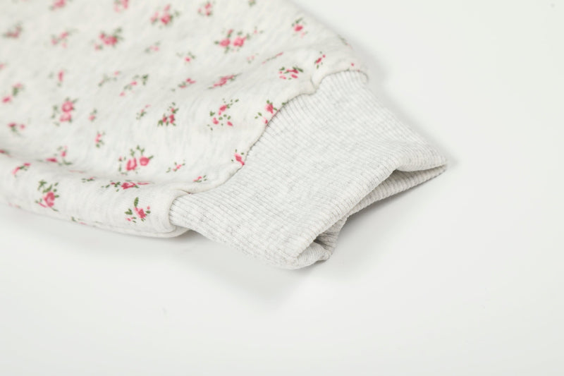 Close-up of ribbed cuff on cream floral hoodie sleeve