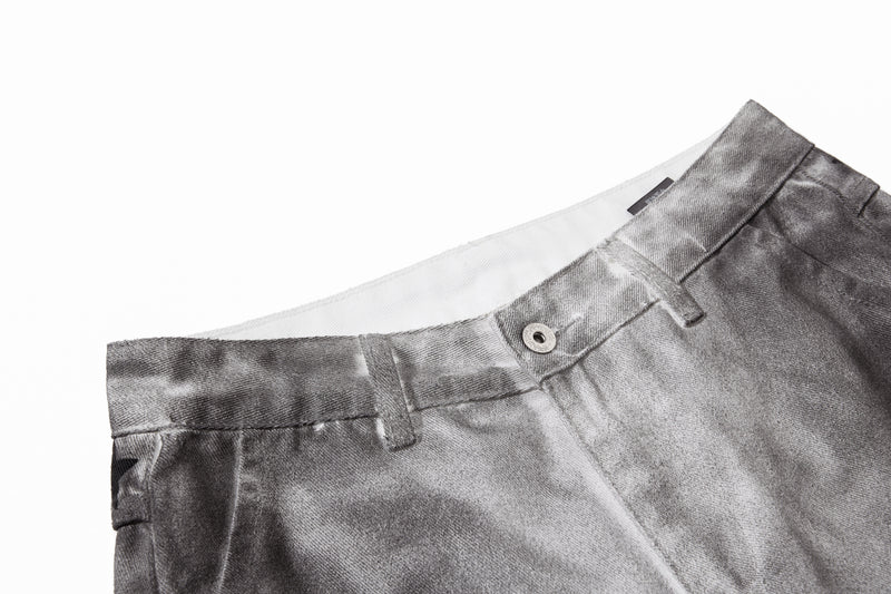 Close-up of gray denim waistband with belt loops, button closure, and white inner lining