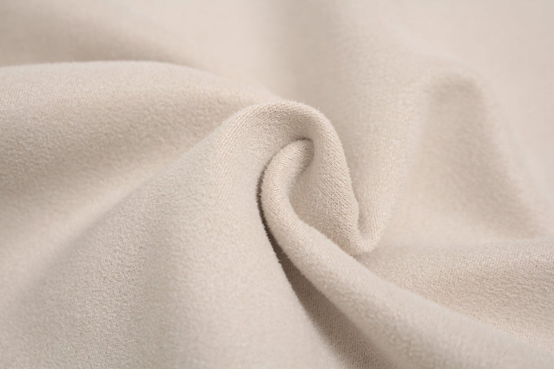 Close-up of soft beige suede-textured fabric with smooth drape for an athletic streetwear tee