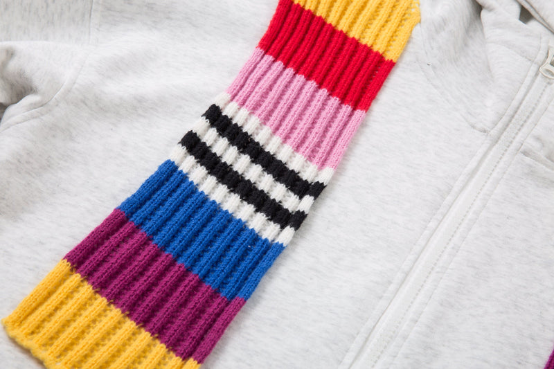 Close-up of a multicolor knitted scarf panel draped over the front of a light gray zip hoodie