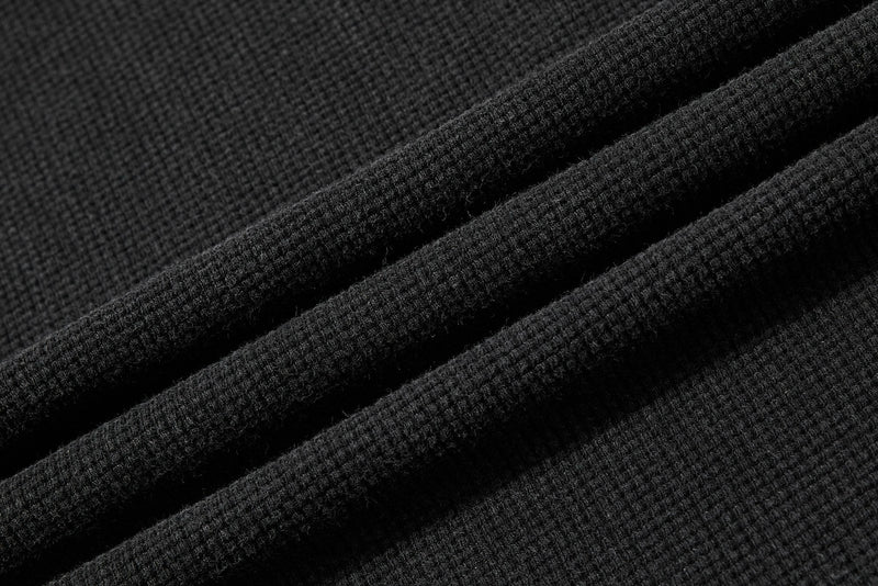 Close-up of black waffle knit fabric with soft ribbed texture on a vintage graphic T-shirt
