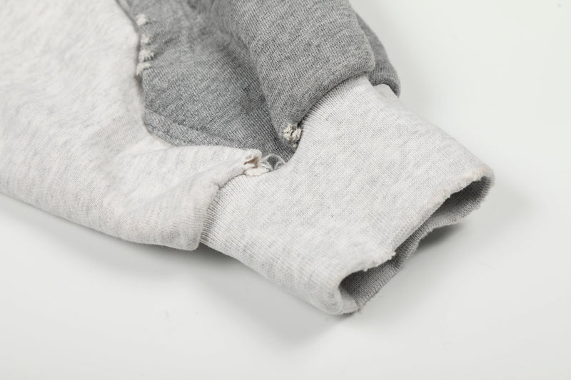Close-up of sleeve cuff and ribbed wrist trim on white and gray hoodie